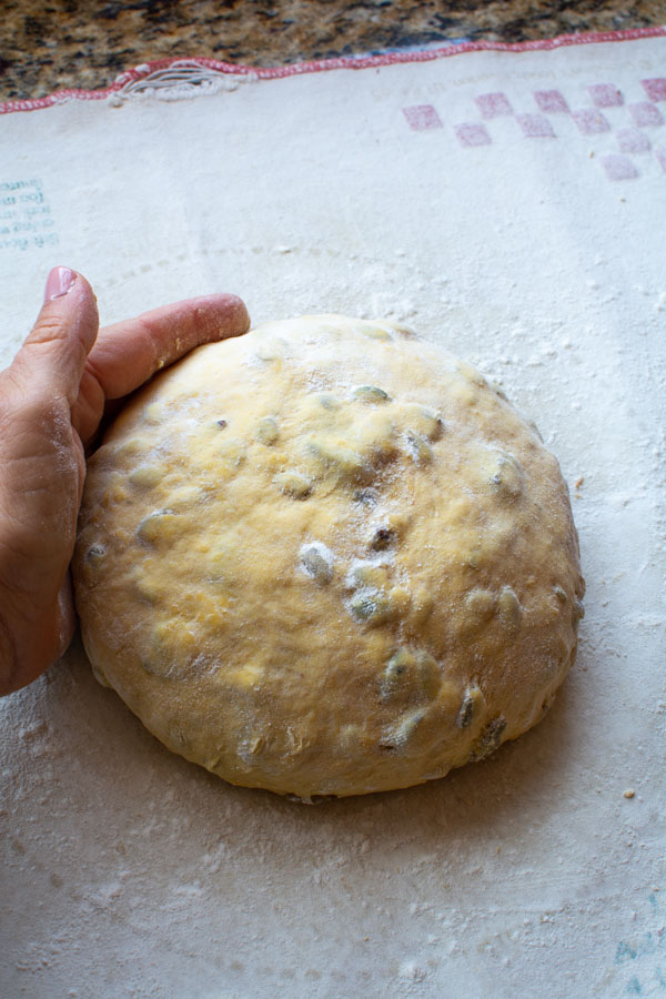 Hand shaping the smooth dough into a round ball.