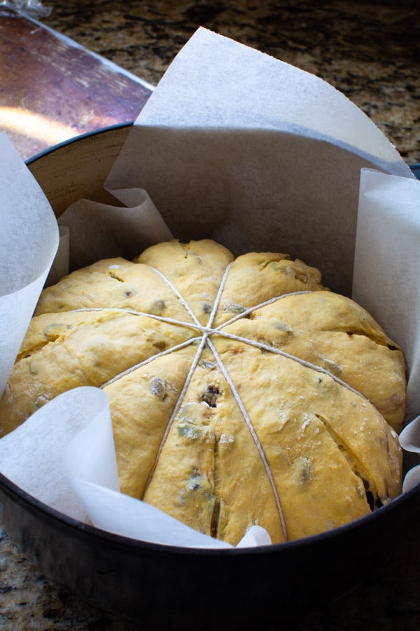 The pumpkin-shaped raw dough placed in a dutch oven with parchment paper.
