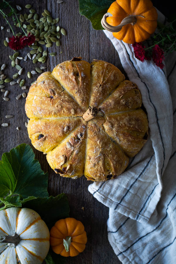overhead shot of a Golden pumpkin shaped bread with a cinnamon stick in the top for a stem