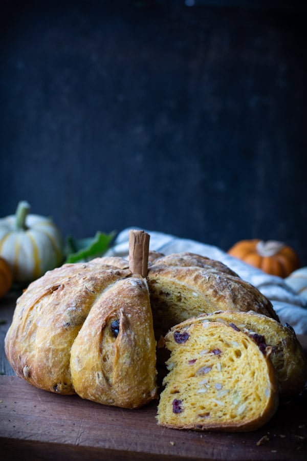 Loaf of pumpkin-shaped bread filled with fruits and nuts.