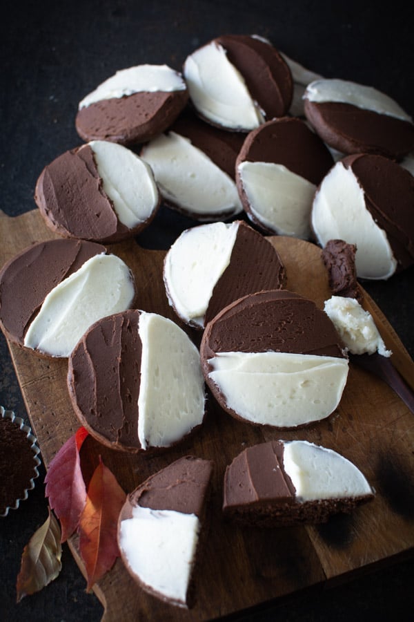 Wooden board with chocolate cookies with half chocolate icing and half vanilla icing