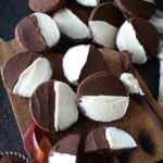 Wooden cutting board stacked with Chocolate Half Moon Cookies