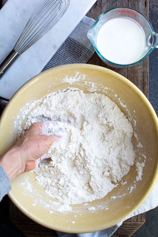 hands rubbing butter into flour mixture