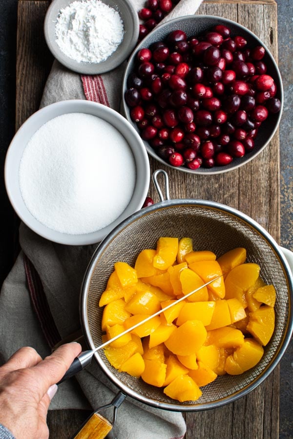 Wire strainer with peaches cutting with a knive