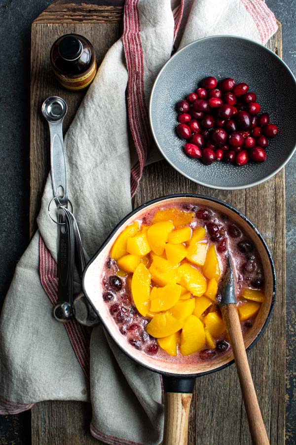 Sauce pan filled with cranberry filling and peaches