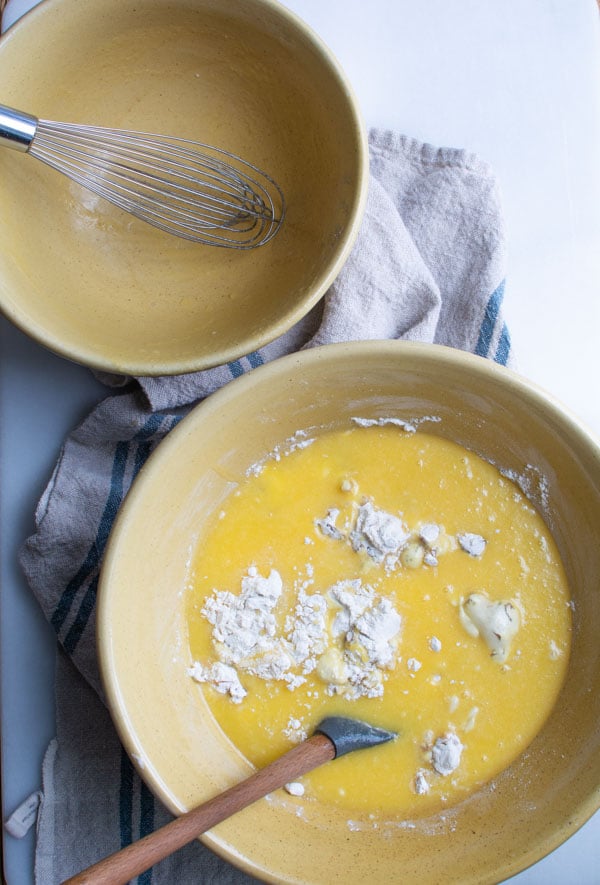 Large mixing bowl with butter mixture poured over the flour fruit mixture.