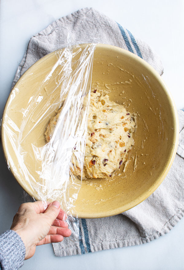 Stollen dough in large bowl covered with plastic wrap