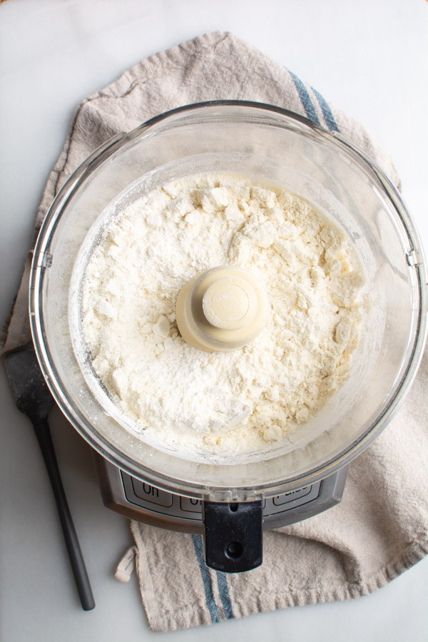 Food processor with almond flour, and powdered sugar.
