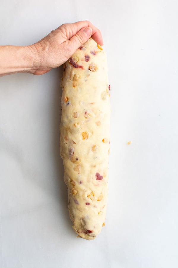 Hand pinching ends of Stollen loaf.