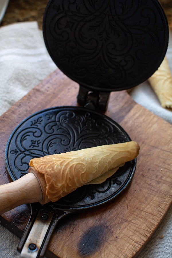 Krumkake around wooden cone form.