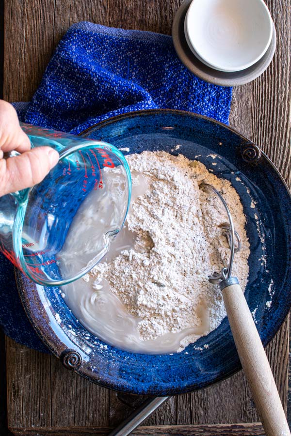 Flour mixture in a bowl with water being added