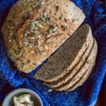 overhead shot of no-knead Dakota Bread on a blue cloth