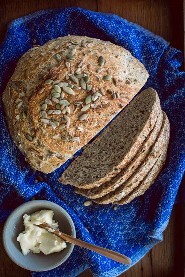 overhead shot of no-knead Dakota Bread on a blue cloth