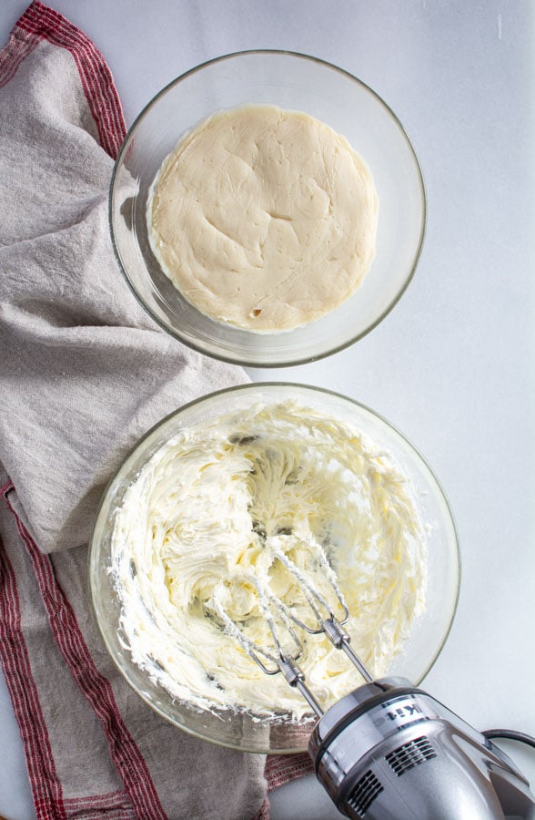 Beaten butter in a bowl with another bowl of roux