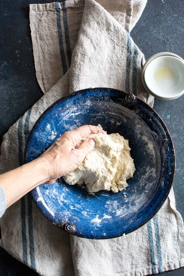 Paratha dough mixed by hand in a large bowl