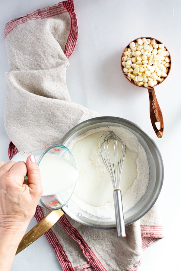 Milk pouring into sugar/flour mixture in a saucepan