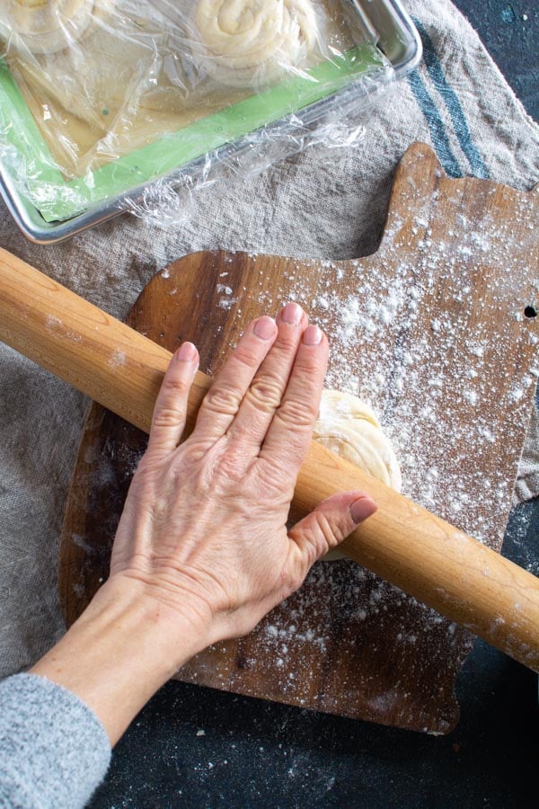 Hand on rolling pin rolling out paratha