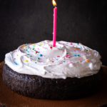 Lit candle on top of Old Fashioned Devil's Food Cake with Boiled Icing
