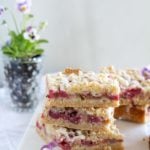 Stacked Strawberry Rhubarb Almond Crumble Bars on a white cloth