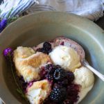 Baked Blackberry cobbler in a bowl with vanilla ice cream