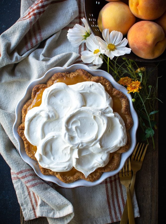 Fresh peach pie topped with whipped cream.