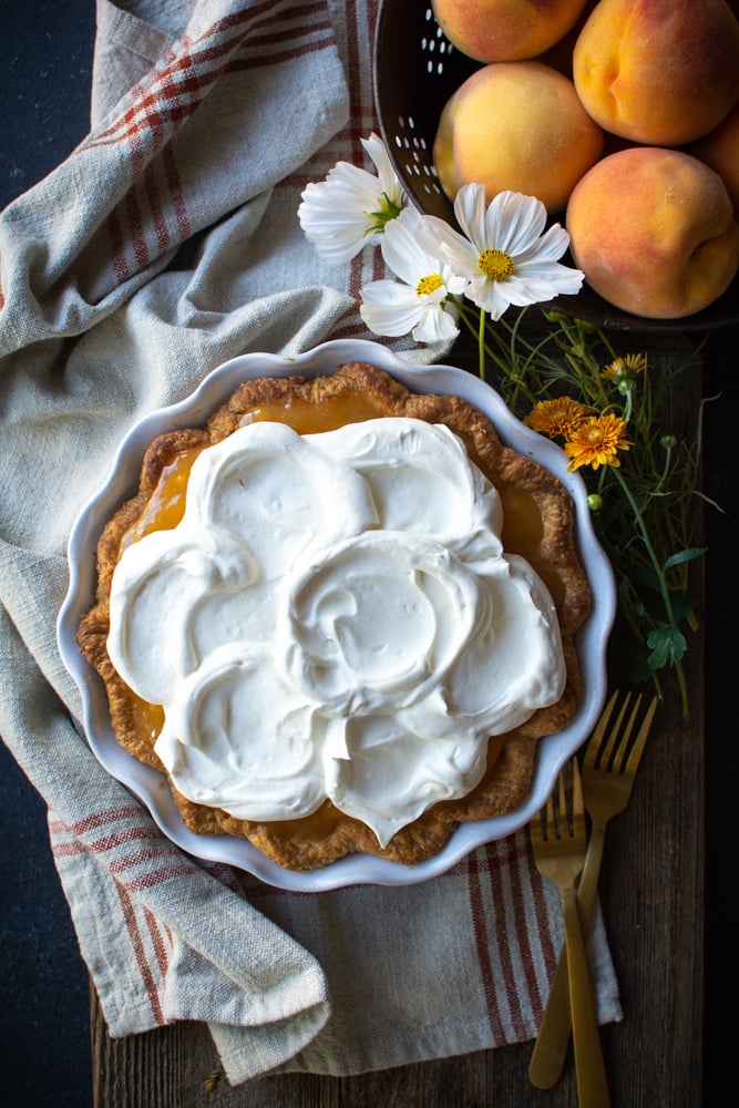 Fresh peach pie topped with whipped cream.