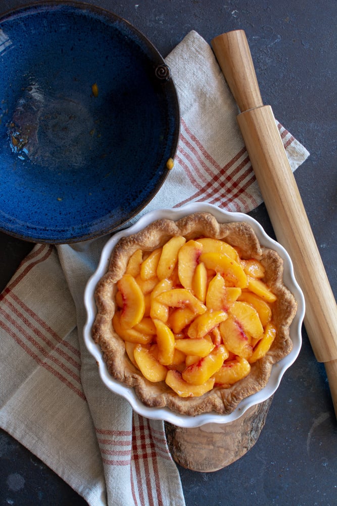 Fresh peaches inside a baked pie shell.