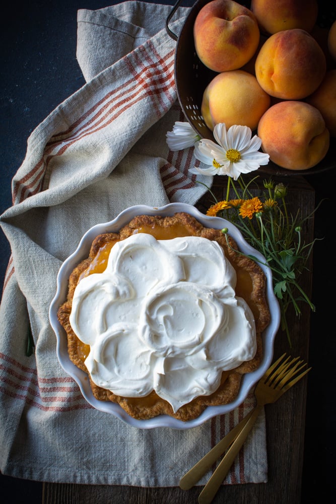 Fresh peach pie topped with whipped cream.