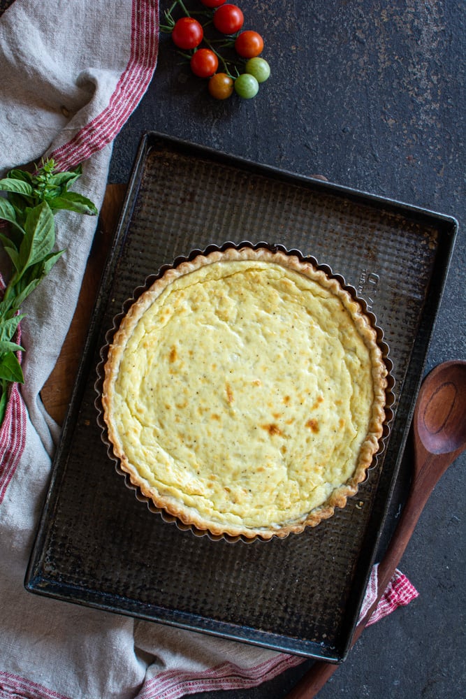 Baked ricotta tart on a black baking sheet