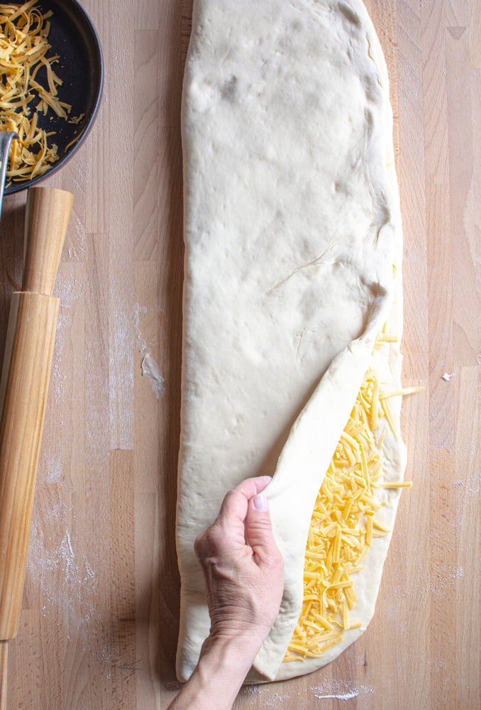 Upper part of dough folded over the other half covered with cheddar cheese