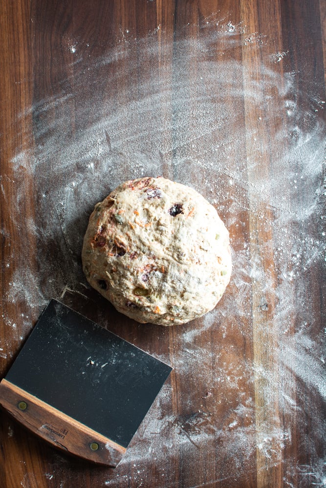 Shaped round loaf of breakfast bread on floured bread board