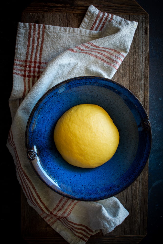 Small ball of pumpkin dough in a blue bowl.