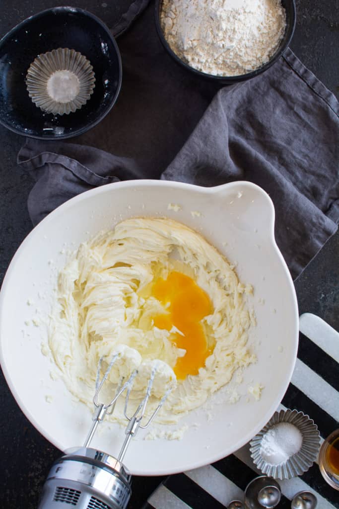 Hand mixer adding egg to the dough.