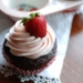 chocolate cupcake with strawberry icing with whole strawberry on top