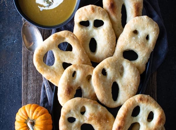 Ghost shaped fougasse on a black platter and wood background