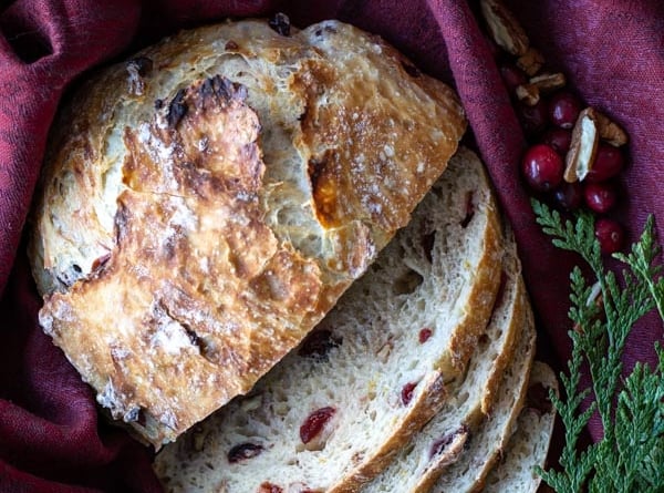 overhead shot of sliced cranberry orange pecan bread on a burgundy cloth