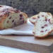 sliced orange cranberry bread on cutting board with 2 slices