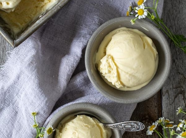 a scoop of homemade vanilla ice cream in two gray bowls