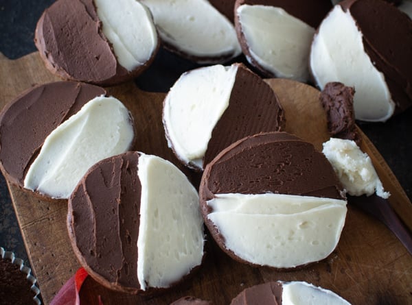 Wooden board with chocolate cookies with half chocolate icing and half vanilla icing